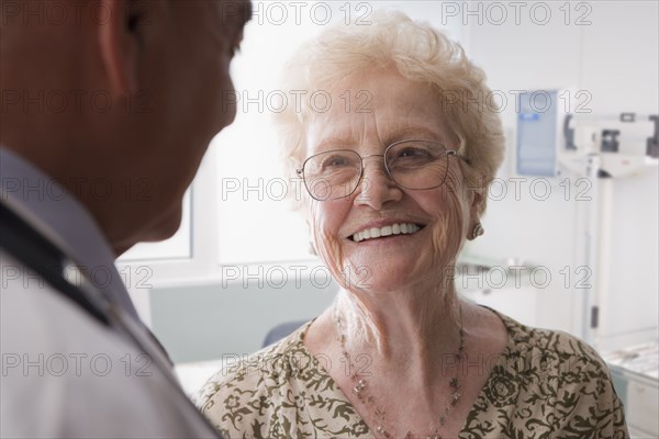 Hispanic doctor talking with older patient
