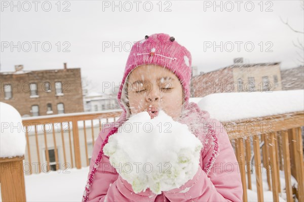 Hispanic girl playing with snowball
