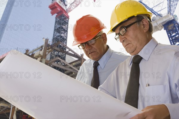 Hispanic businessmen reading blueprints