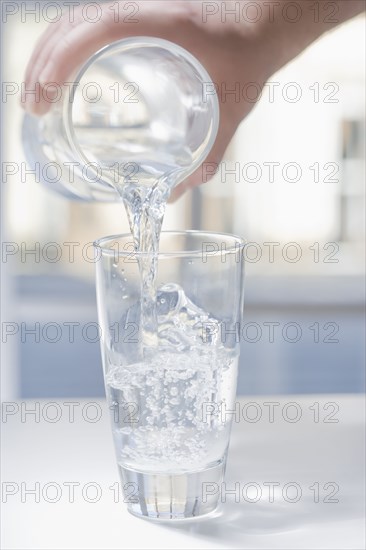 Hispanic man pouring glass of water