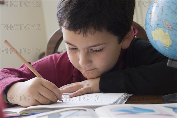 Hispanic boy doing homework at table