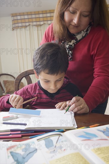 Hispanic mother helping son with homework