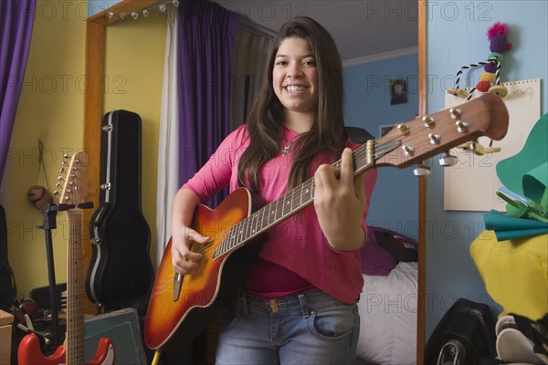 Hispanic girl playing guitar