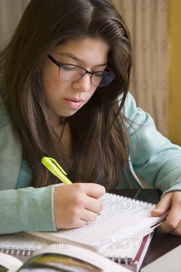 Hispanic girl doing homework at table