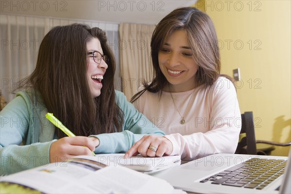 Hispanic mother helping daughter with homework