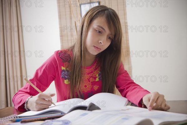 Hispanic girl doing homework at desk