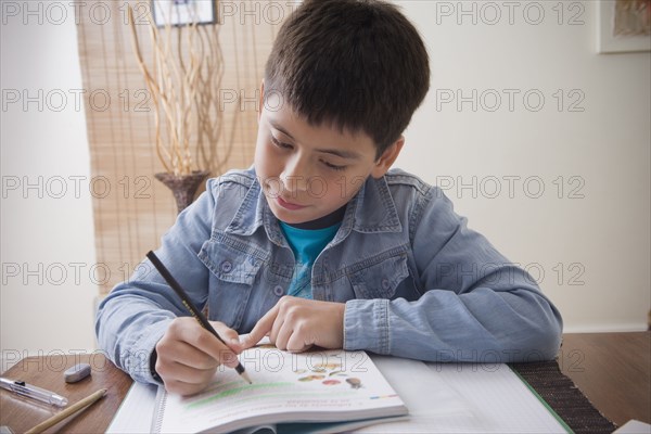 Hispanic boy doing homework at desk