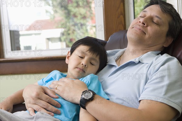 Hispanic father and son napping