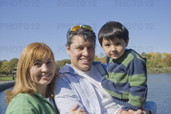 Hispanic family smiling at lakeside
