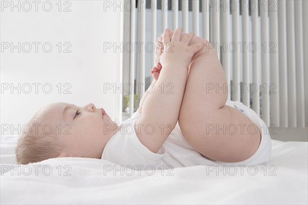 Hispanic baby boy playing with feet