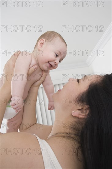 Mother playing with Hispanic baby boy