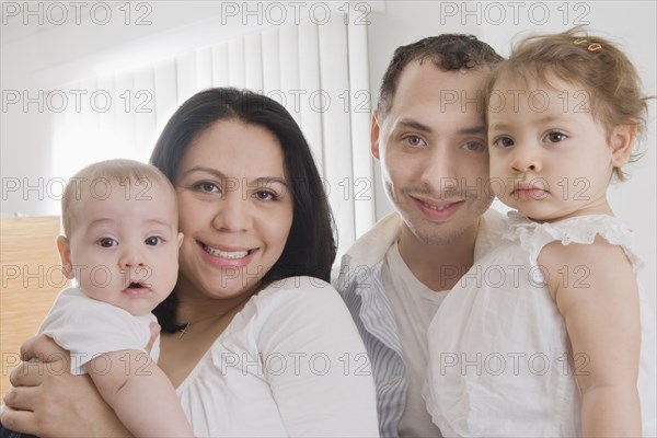 Hispanic family smiling together indoors