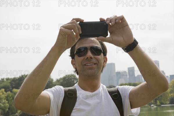 Hispanic man using camera phone