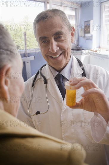 Hispanic doctor giving patient prescription bottle
