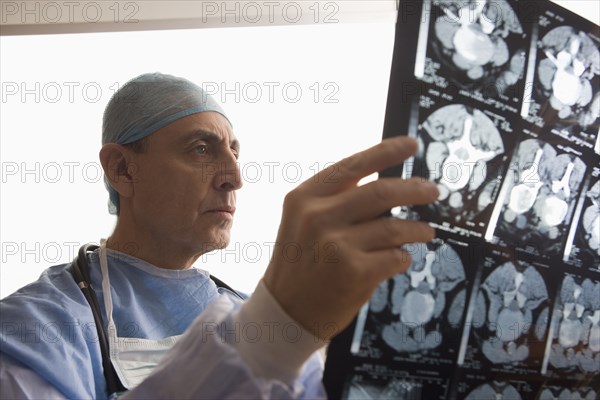 Serious Hispanic surgeon examining x-rays