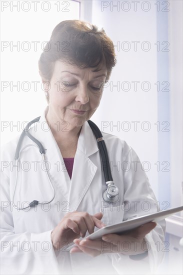 Hispanic doctor using tablet computer in office