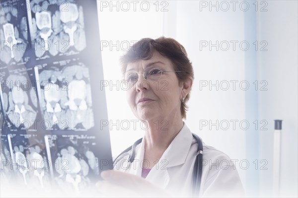 Hispanic doctor examining x-rays in office