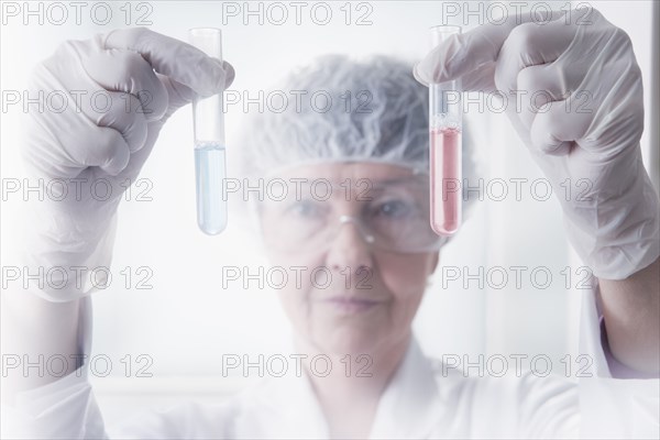 Hispanic scientist examining test tubes in lab
