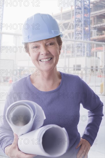 Hispanic architect carrying blueprints