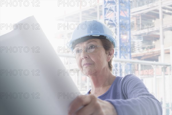 Hispanic architect reading blueprints