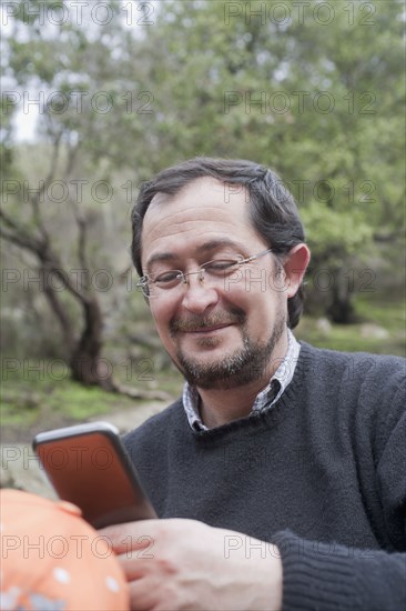 Hispanic man using cell phone in park