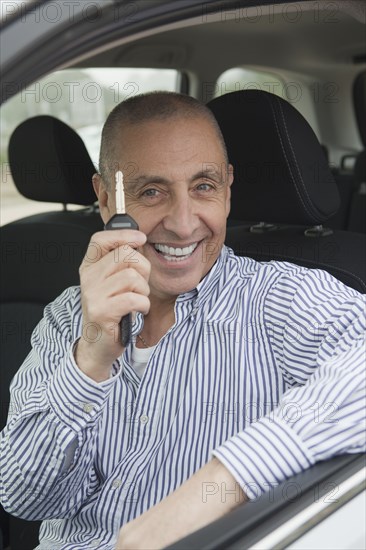 Hispanic senior man holding new car key