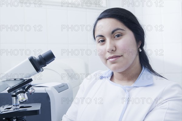 Hispanic scientist smiling in laboratory
