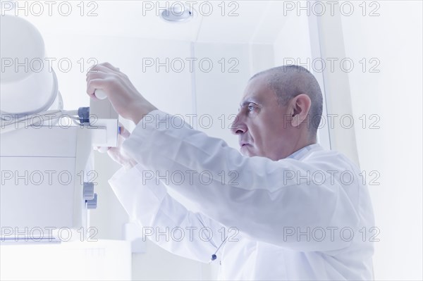 Hispanic doctor using x-ray machine