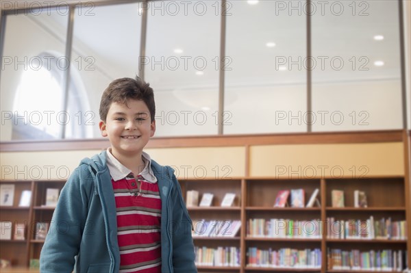 Hispanic boy smiling in library