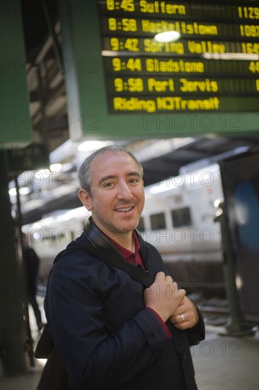 Hispanic man standing on platform in train station