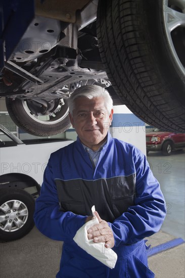 Older Hispanic mechanic working in garage