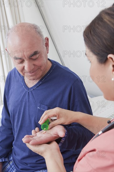 Hispanic nurse giving patient medication