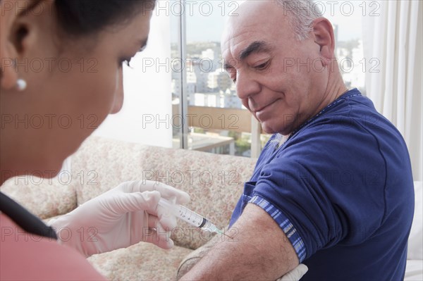 Hispanic nurse giving patient injection