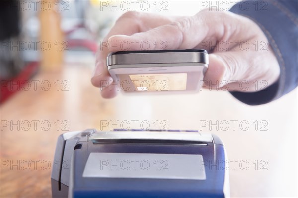 Hispanic woman scanning credit card from cell phone