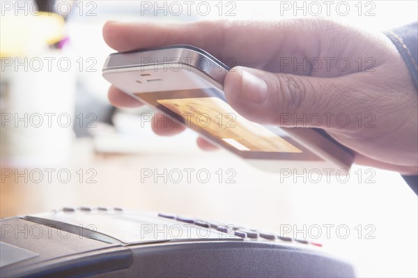 Hispanic woman scanning credit card from cell phone