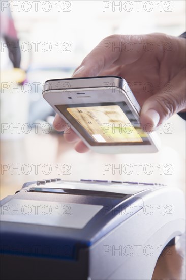 Hispanic woman scanning credit card from cell phone