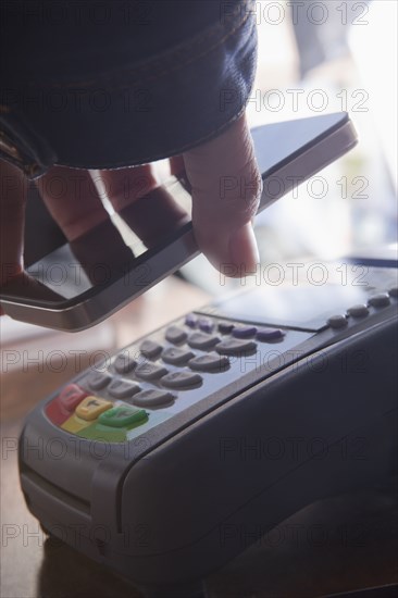 Hispanic woman scanning credit card from cell phone