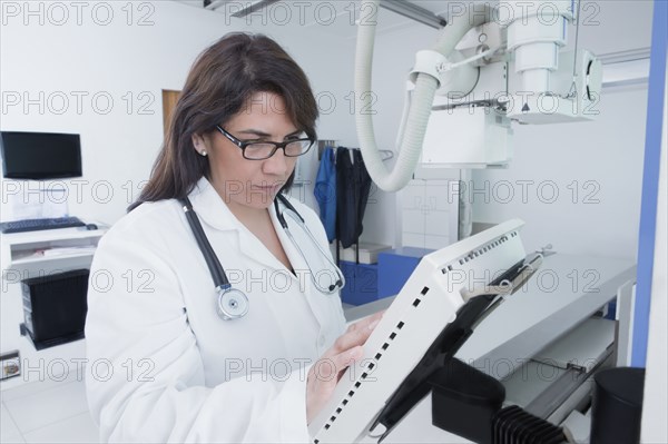 Hispanic doctor using x-ray in hospital