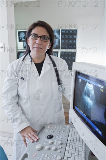 Hispanic doctor examining sonogram in hospital