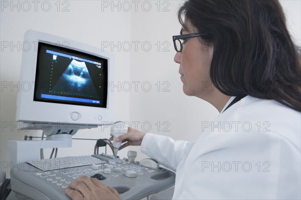 Hispanic doctor examining sonogram in hospital