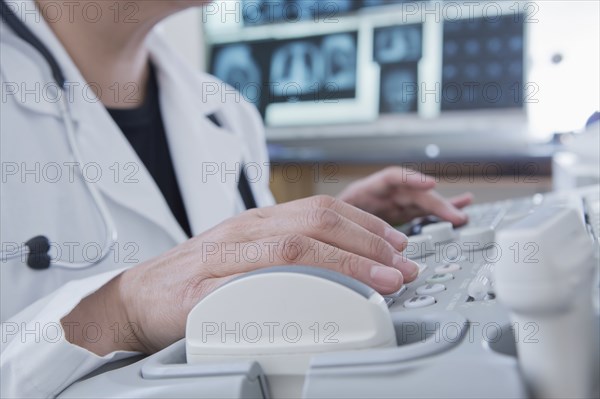 Hispanic doctor using machinery in hospital