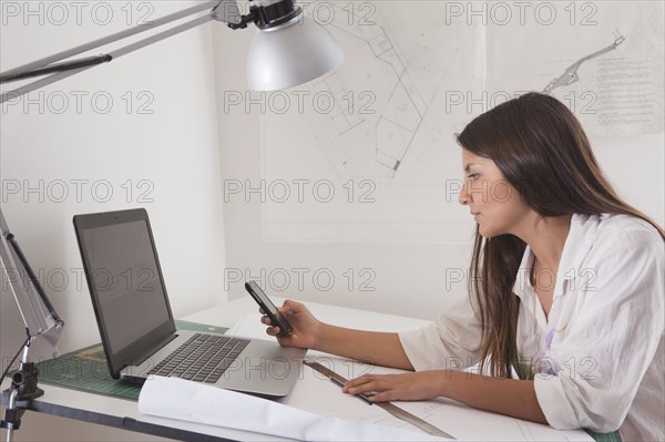 Hispanic architect working at drafting table