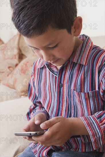 Hispanic boy texting on cell phone