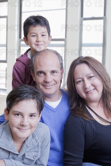 Hispanic mother and father posing with sons