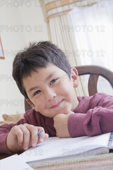 Hispanic boy doing homework at table