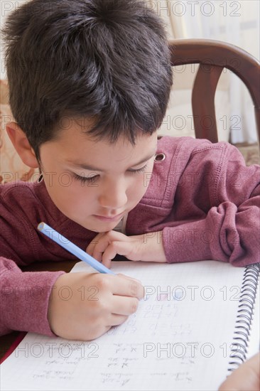 Hispanic boy doing homework at table