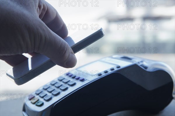 Hispanic man paying with smart phone