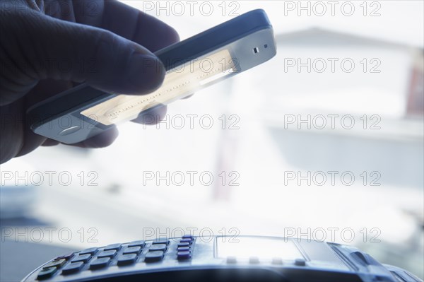 Hispanic man paying with smart phone