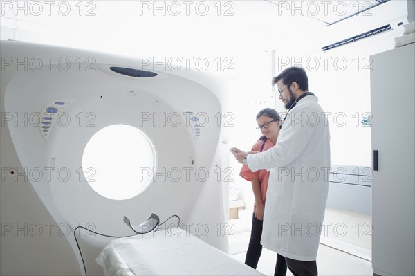 Hispanic doctor and nurse talking near scanner