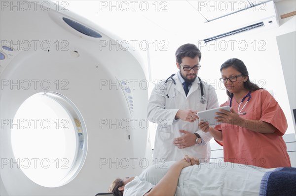 Hispanic doctor and nurse using digital tablet near scanner